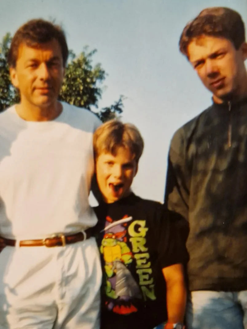 An old family snapshot. A boy in a Ninja Turtles t-shirt pulls a face for the camera.