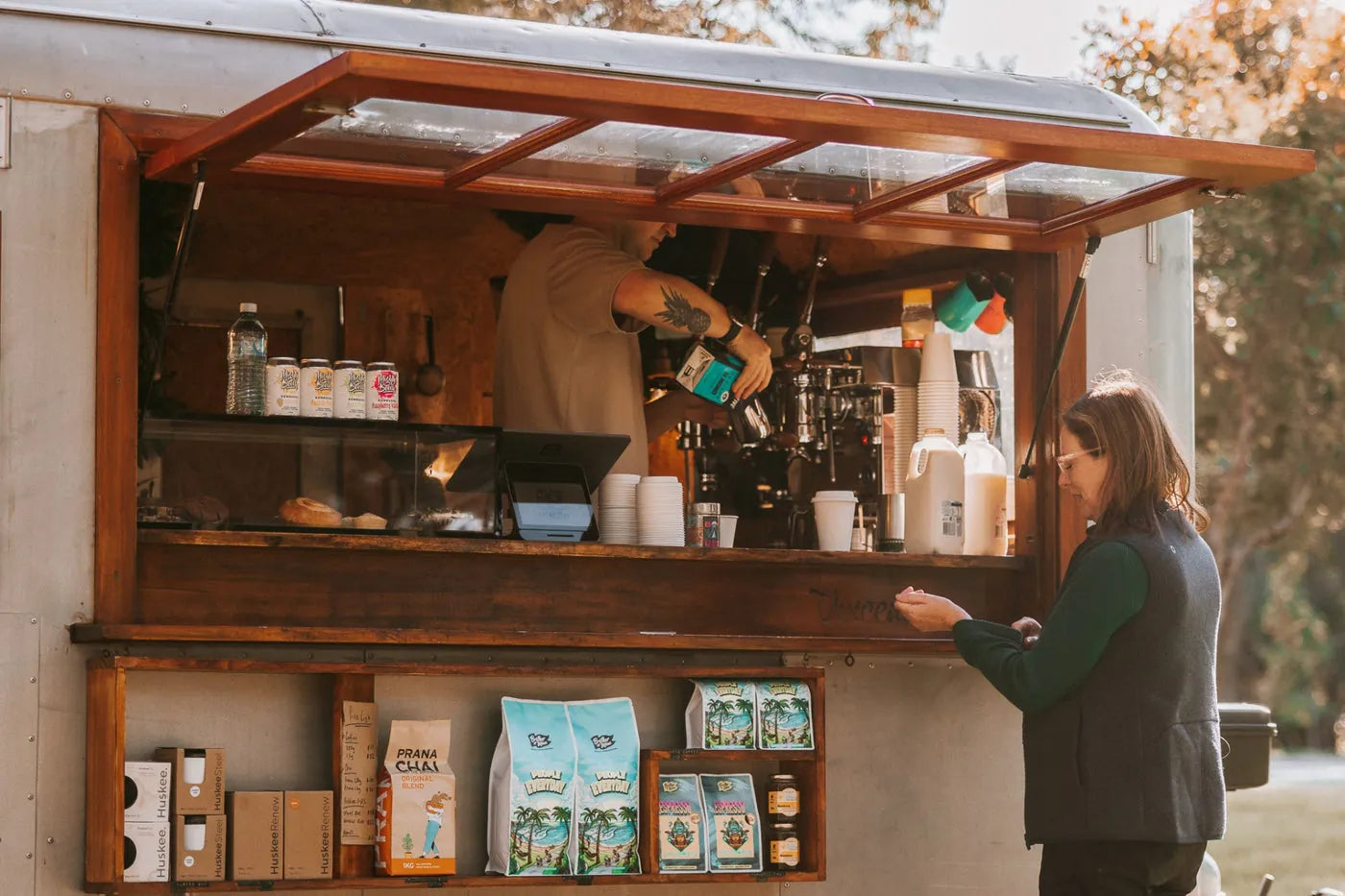 A wholesale partner serving a customer at his coffee cart