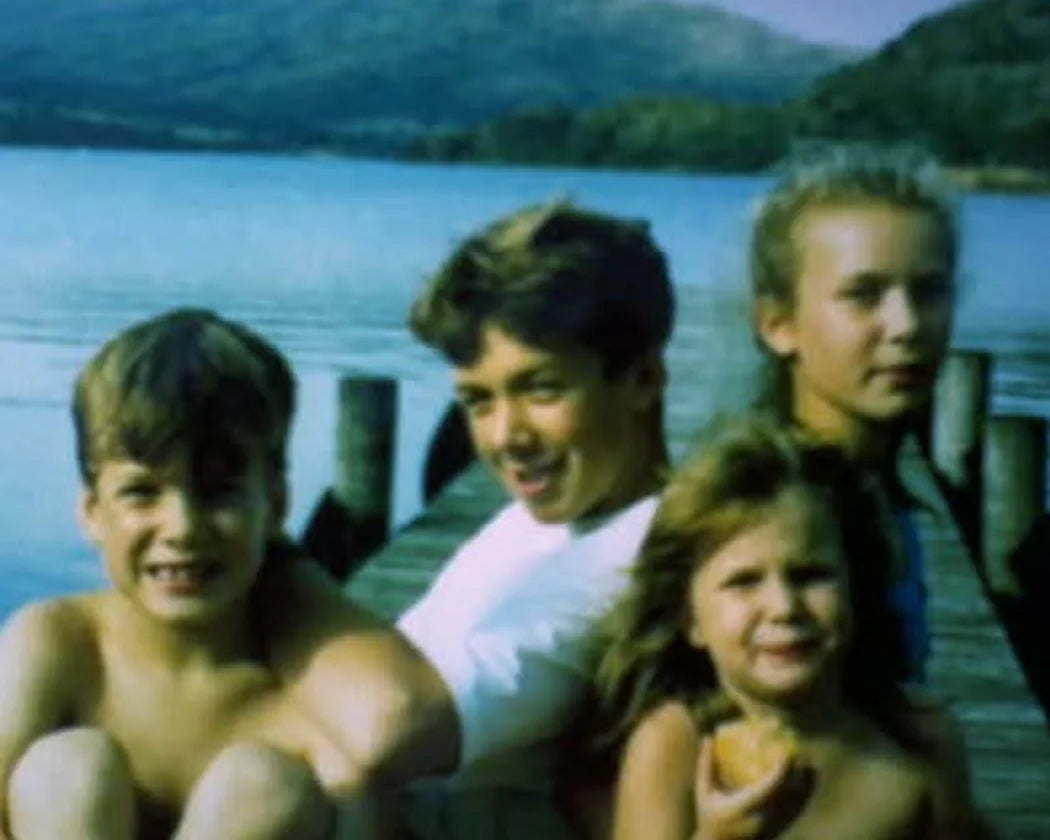 Four kids on a jetty by a lake: the two of us with our sisters, Abbie and Polly.